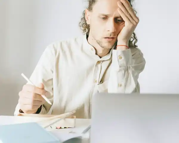 Frustrated man dealing with the pet relocation paperwork, highlighting common costly mistakes in bird shipping and pet transport.